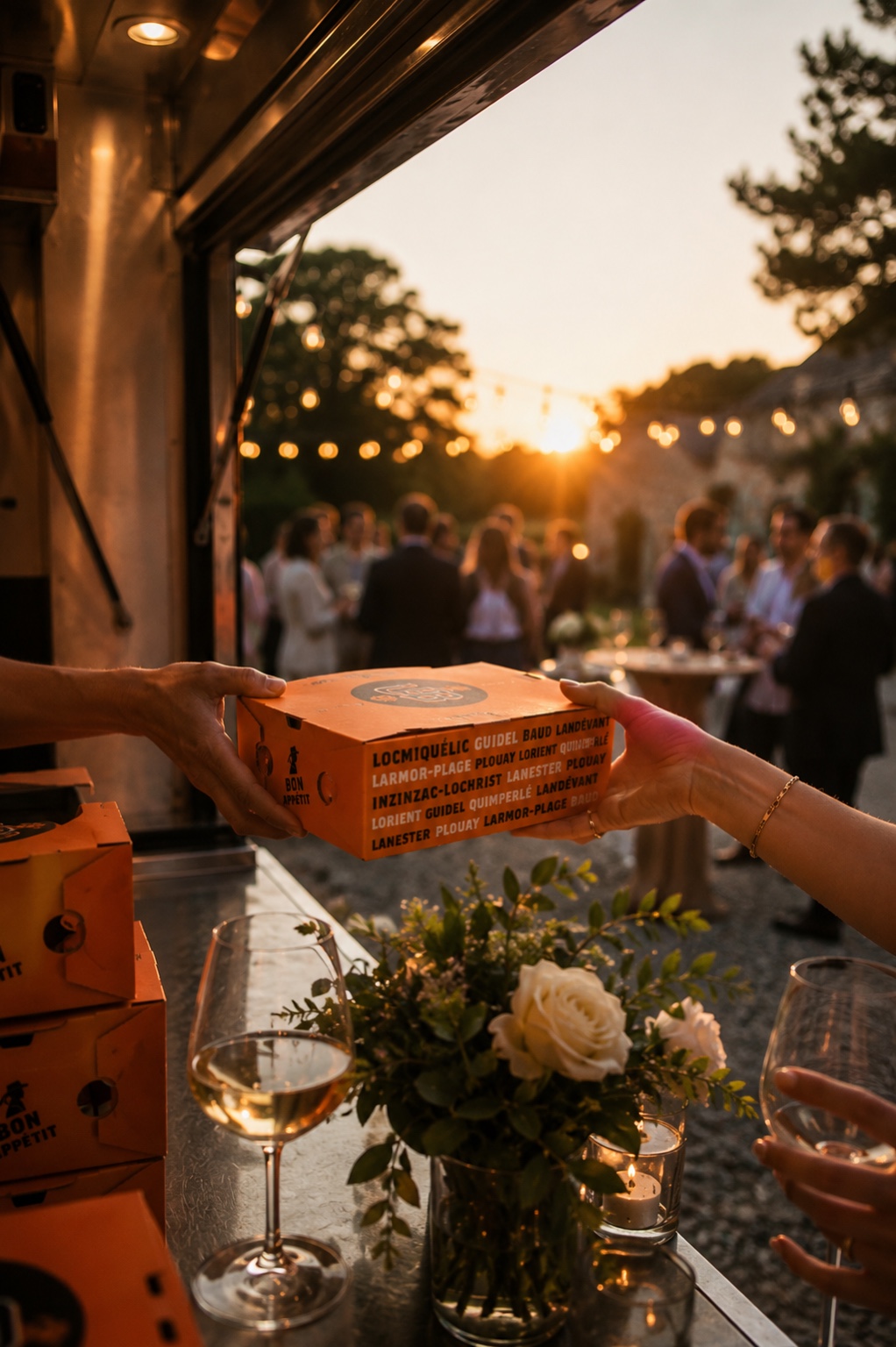 Un burger Uncle Breizh remis à une invitée pendant une réception au coucher du soleil